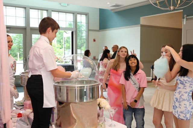 Party guests gathered around the cotton candy station indoors
