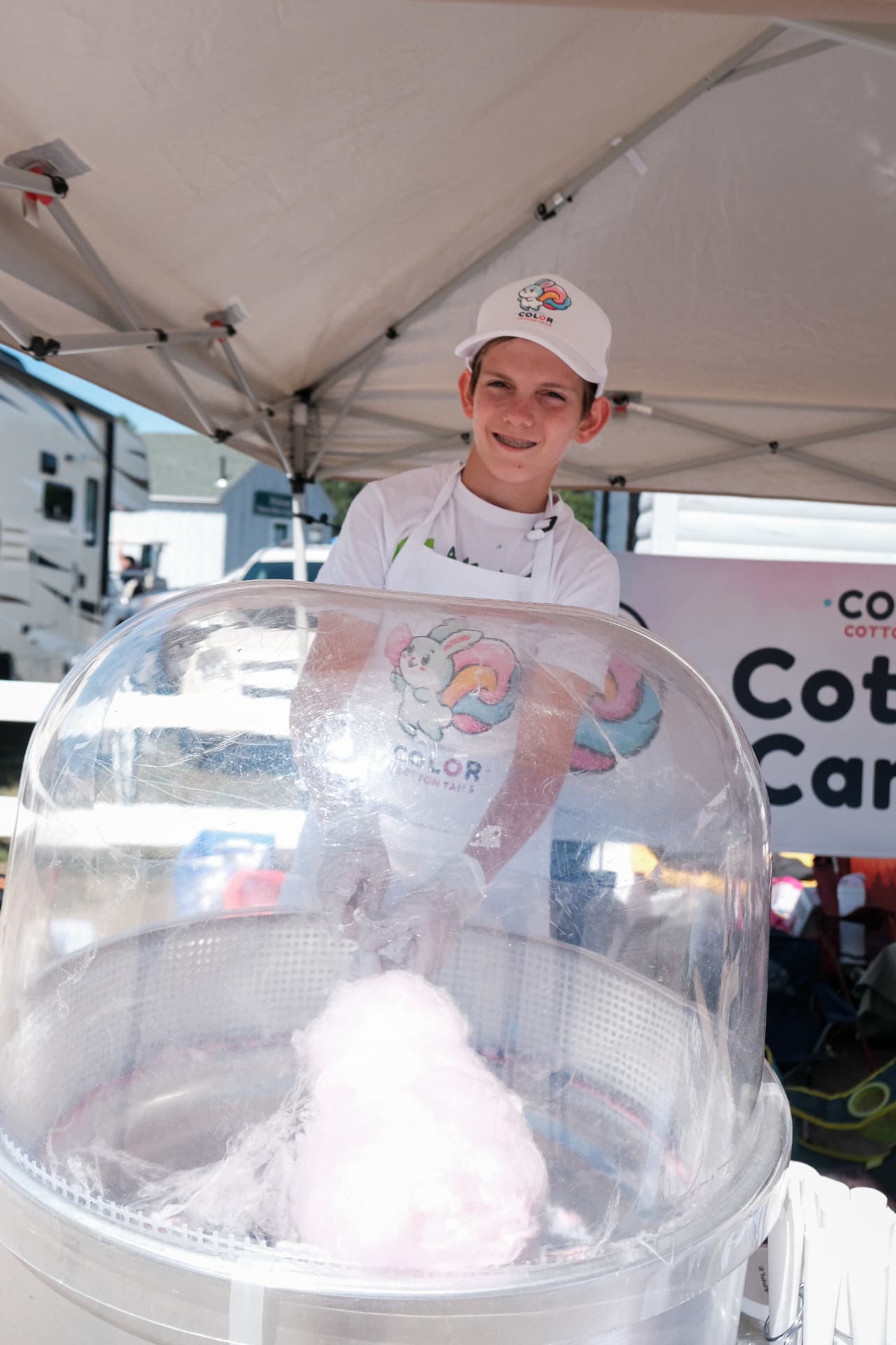 Liam smiling behind the cotton candy machine